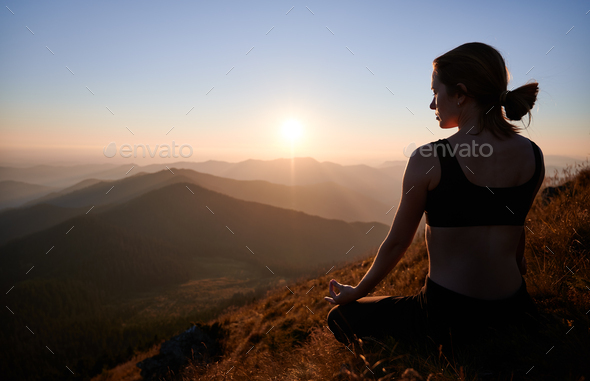 Young woman sitting in yoga pose in mountains between spiral of stones  Stock Photo - Alamy