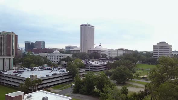 Rising to reveal downtown Tallahassee skyline and Florida state capitol, aerial, pedestal. alt