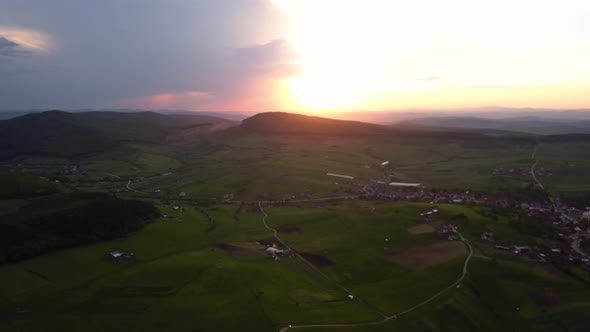 Panorama aerial shot of a beautiful sunset over open country with green meadows and fields, Transylv alt