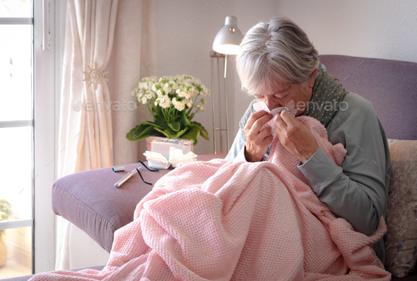 Elderly adult caucasian woman with cough and fever symptoms such as seasonal flu or pollen allergy