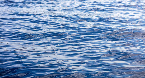 Sea water surface calm with small ripple. Still ocean, deep blue color background. Aegean Sea.