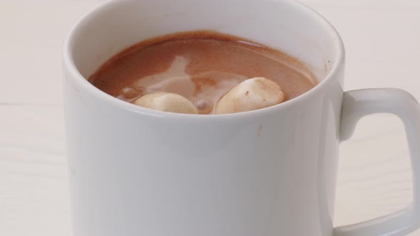 Mini Marshmallows Falling Into a Cup of Cocoa Drink Close Up