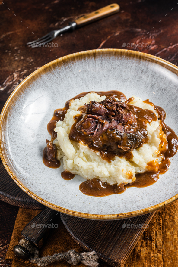 Slow cooked beef cheeks in red wine sauce with mashed potato. Dark