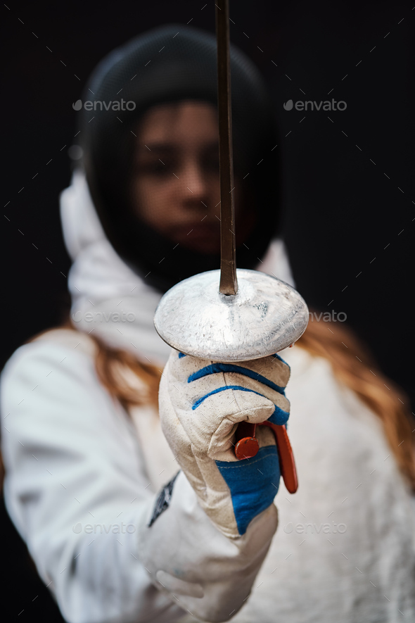 Portrait of woman dressed in fencing costume on black background. Stock ...