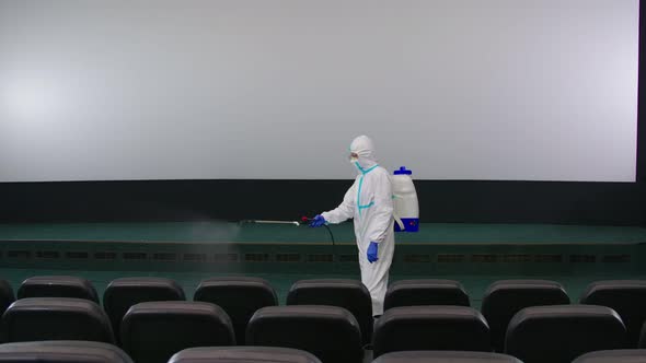Worker Cleaning Cinema Hall with Against Coronavirus alt