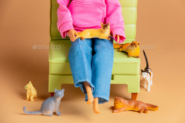 Cat lady with a lot cats in a armchair. Scene with dolls