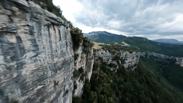 Dynamic Drone Shot Along Rocky Mountain Cliff Turns to a Dive