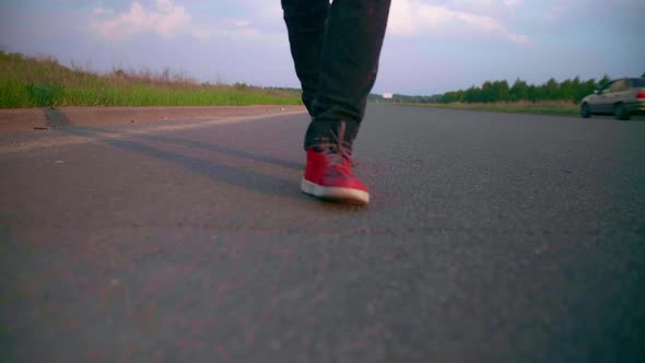 Motorcyclist Walks on the Road to His Motorcycle Chopper