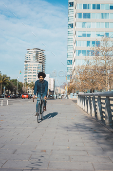 Man with afro hair riding a vintage style bicycle