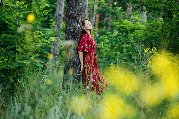 Nature Impact Wellbeing. Woman in red dress enjoying nature.