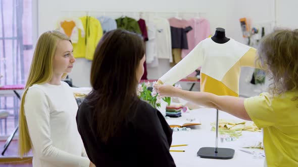 Shot of Three Fashion Designers Working and Deciding Details of New Collection of Clothes in the