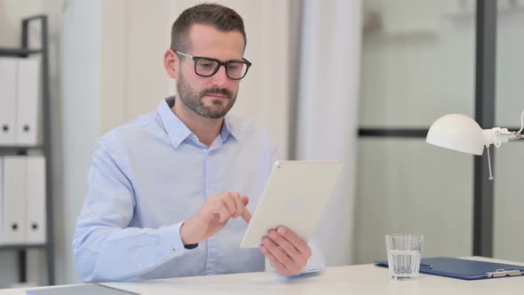 Middle Aged Man Using Tablet at Work alt