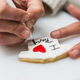 Woman writing sentences about decorated cookies in bakery - PhotoDune Item for Sale