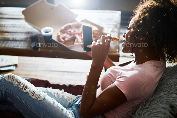 woman staying up late relaxing at home watching tv and eating pizza