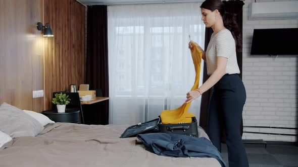 Beautiful Woman Packing Clothes in Suitcase Then Leaving Hotel Room Finishing Vacation alt