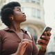 African American young thoughtful woman looking for destination using navigation on smartphone - PhotoDune Item for Sale