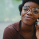Close up African girl in glasses smiling looking away while talk - PhotoDune Item for Sale