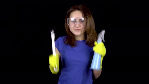 A Young Woman Is Dancing with a Toilet Brush and Spray, Woman in Safety Glasses and Gloves alt