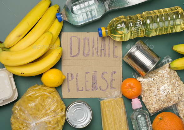 Inscription on the cardboard please donate various products. Fresh fruits, pasta and canned food