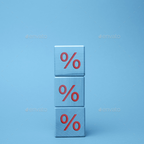 Wooden blocks with percent on a blue background. The concept of reducing or increasing prices - Stock Photo - Images