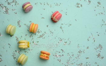 Baked macarons with different flavors on a green background