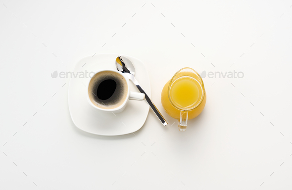 Freshly squeezed juice in a glass transparent decanter, a cup of coffee