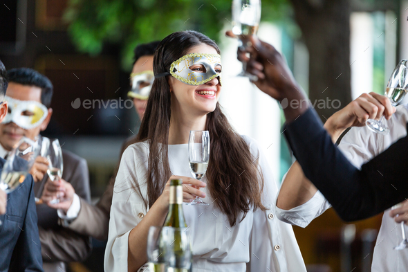 Happy group of office worker in fancy mask enjoy drinking in the party