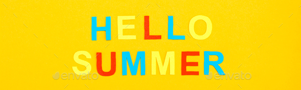 Hello summer. The inscription of colored carved letters on a yellow cardboard. Top view. Web banner