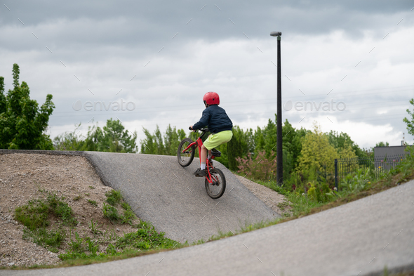 Child riding his bmx bike on a pump track
