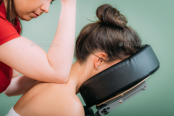 Chair Massage in the Office. Female sitting in her office on a portable massage chair.