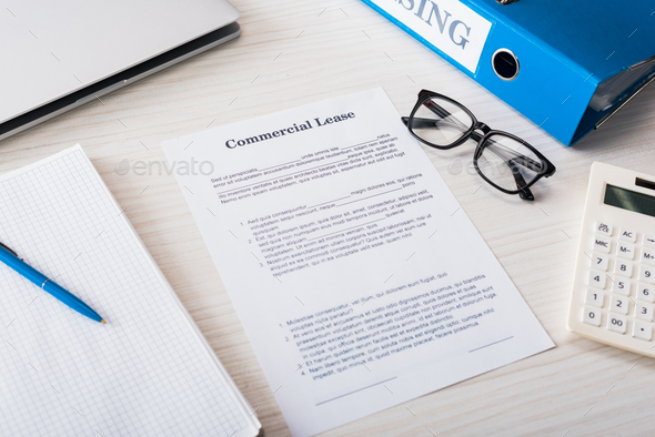 top view of folder, calculator, pen and glasses near document with commercial lease lettering on - Stock Photo - Images