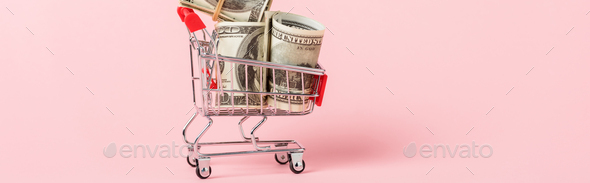 panoramic shot of toy shopping trolley with dollar banknotes on pink, leasing concept - Stock Photo - Images