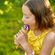 Happy girl with braces eating italian ice cream cone smiling while resting in park on summer day - PhotoDune Item for Sale