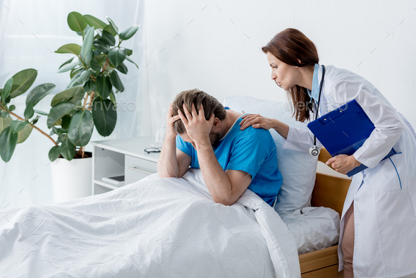doctor in white coat calming down upset patient in hospital