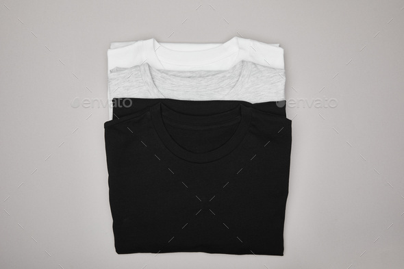 top view of blank basic black, white and grey t-shirts isolated on grey