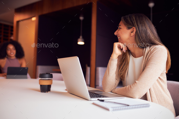 Businesswoman With Laptop At Socially Distanced Meeting In Office During Health Pandemic