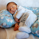 A few days old baby sleeps on a round pillow. The sleep phase is very important in childhood. - PhotoDune Item for Sale