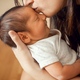 A few days old baby is kissed by his mother on the forehead. - PhotoDune Item for Sale
