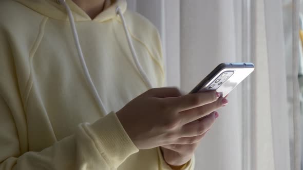Closeup view on teen female hand using mobile phone