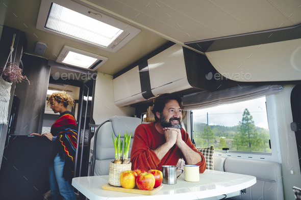 Travel people and off grid lifestyle living van life inside a camper. Happy serene couple enjoy van