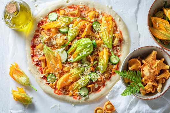 Ingredients for vegetarian pizza with zucchini, chanterelles and mozzarella.