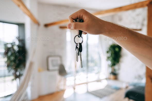Man hand showing keys of new home, moving and buying new apartment concept.