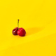 Closeup of red cherries with shadow isolated on a yellow background - PhotoDune Item for Sale