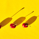 Top view of three red cherries with shadow isolated on a yellow background - PhotoDune Item for Sale