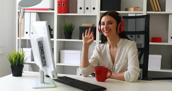Businesswoman Listening Music, Looking To Monitor and Waving Hand at Camera