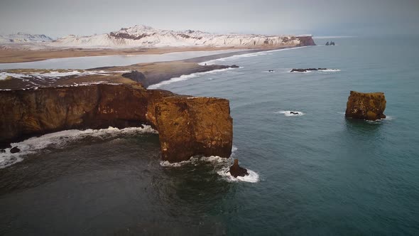 Aerial view of Dyrholaey peninsula with the black arch of lava. alt