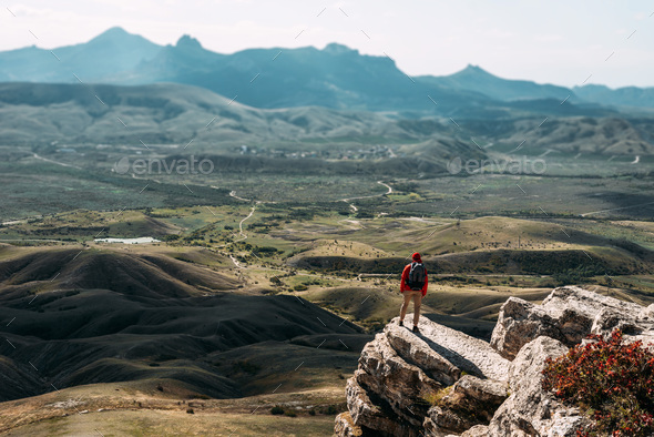 A traveler with a backpack in the mountains. Hiking in the mountains - Stock Photo - Images