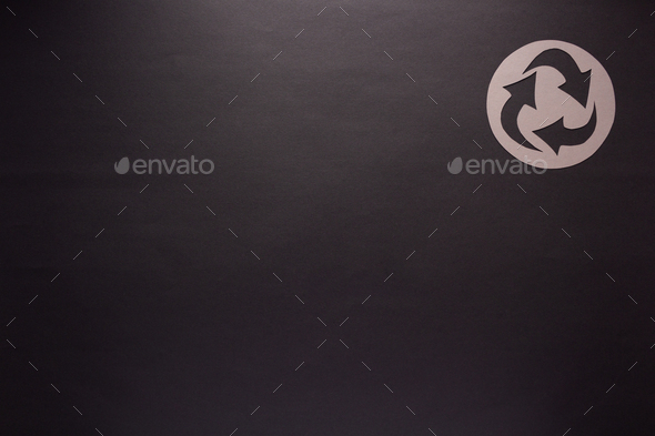 Recycle symbol on black paper as background texture. Recycling concept