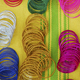 Coloured bangles paid out on a yellow and green striped background. - PhotoDune Item for Sale
