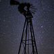 A windmill tower at night, against a starry sky, low angle view. - PhotoDune Item for Sale